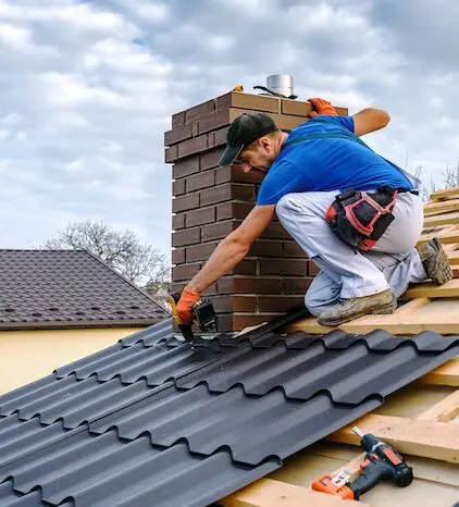 Roofer installing metal roofing sheets