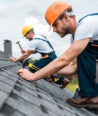 Roofers working on shingles installation