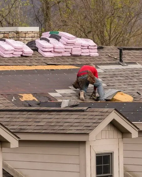 Roof construction worker installing shingles