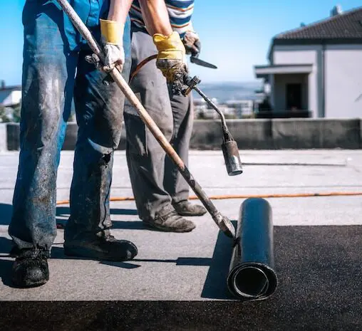 Roofing workers applying waterproof sealant