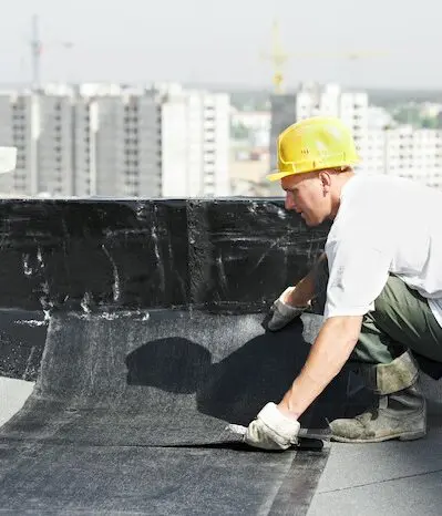 Roofer installing waterproof membrane rooftop