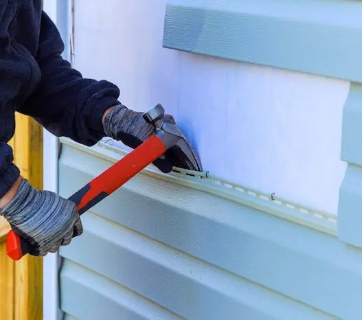 Person installing home exterior siding