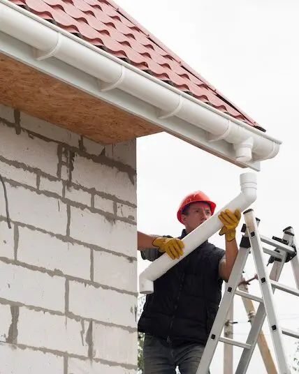 Worker installing house gutters system