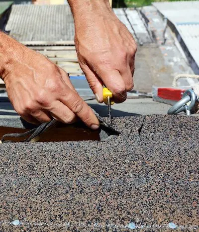 Roof repair handyman fixing shingles